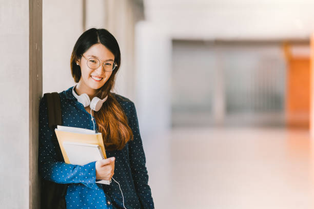 giovane bella liceale asiatica o studentessa universitaria che indossa occhiali da vista, sorridente nel campus universitario con spazio di copia. concetto di educazione, geek o nerd - japanese ethnicity college student student asian ethnicity foto e immagini stock