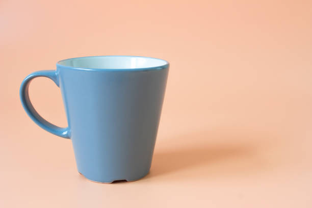 istock gray cup on the orange background / copy space for message or product 990455242
