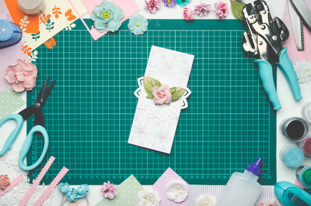 istock Multi-colored paper card on the cutting mat, tools and materials for scrapbooking 990458100