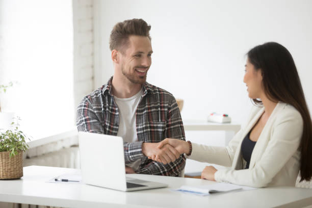 istock Smiling colleagues handshaking after successful cooperation 990458592