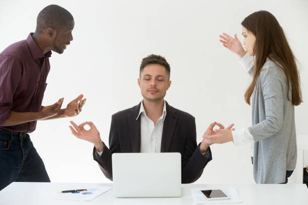istock Caucasian employee meditating at workplace ignoring colleagues 990458784
