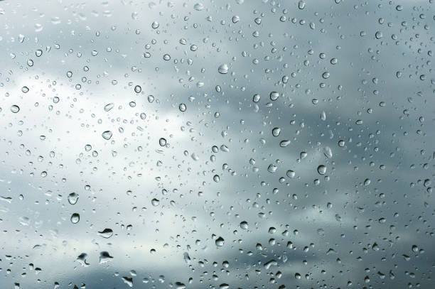istock Textured background of window panes with a cloudy background. Natural pattern from a drop of rain on a cloudy background 990483174
