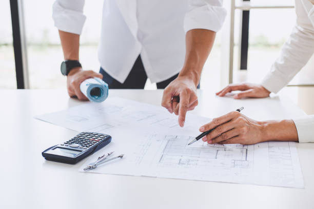 istock Architect or Engineer meeting working with partner on blueprint for architectural project in progress, construction and structure concept 990485288