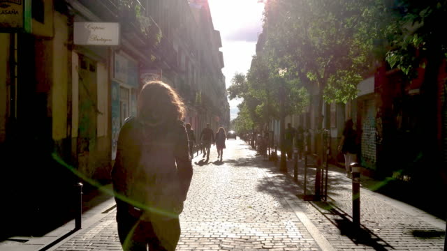 Girl walking in the streets of malasaña madrid at sunset