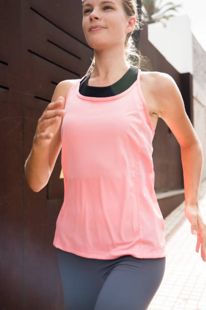 istock Young girl running past a brown building 990505250