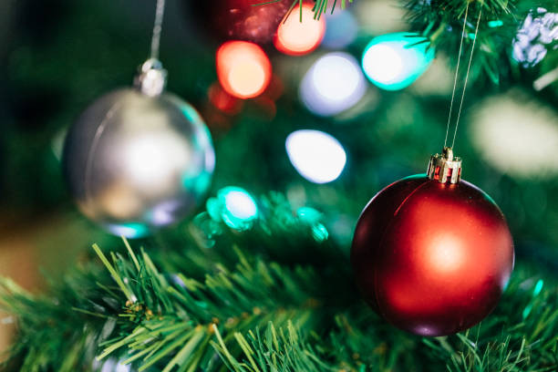 istock Close look at Christmas baubles hanging from a Christmas tree. 990505866