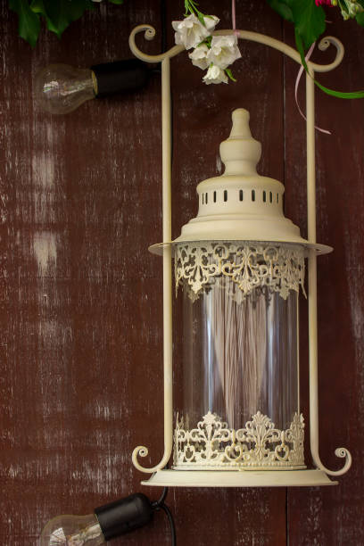 istock White lantern on browm wooden background or fence. 990524386