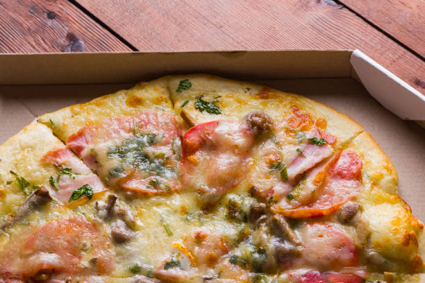 Italian pizza on wooden boards, pizza with bacon, dried tomatoes and Parmesan cheese, Italian cuisine, appetizing dish with meat and cheese, copy space
