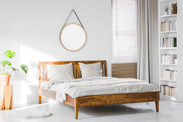 istock A wooden rustic bed frame and a home library bookcase in a natural, sunlit hotel room interior with white walls 990530714