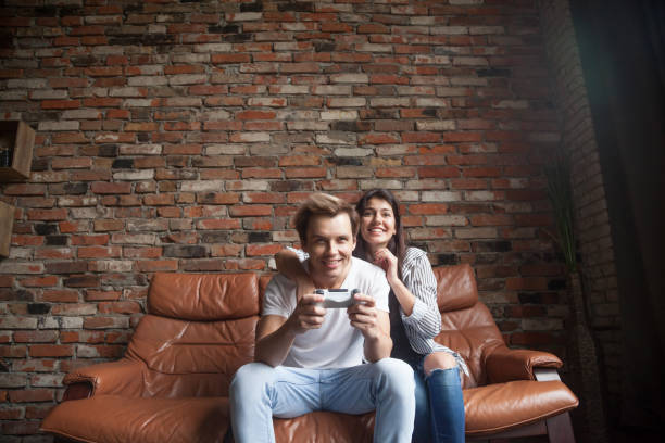 szczęśliwa tysiącletnia para grająca w gry wideo w domu - video game friendship teenager togetherness zdjęcia i obrazy z banku zdjęć
