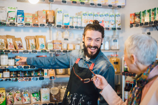 istock Happy sales man pointing hands towards jars on the shelf 990541238