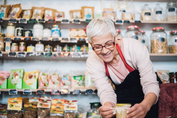 istock Smiling elderly woman decorating jar at the shop 990542276