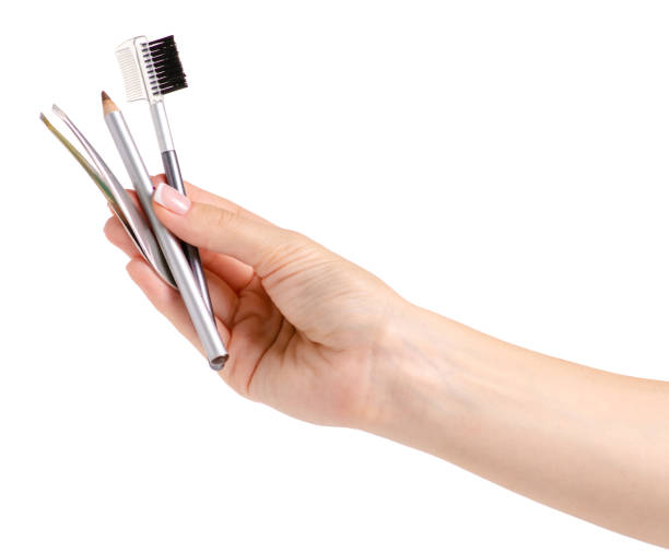 istock Brush for eyebrow pencil tweezers in hands 990542618