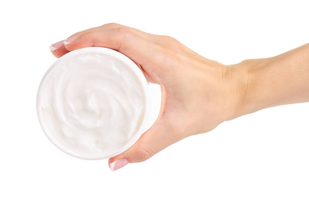 istock White jar of cream for a body in hands 990542720
