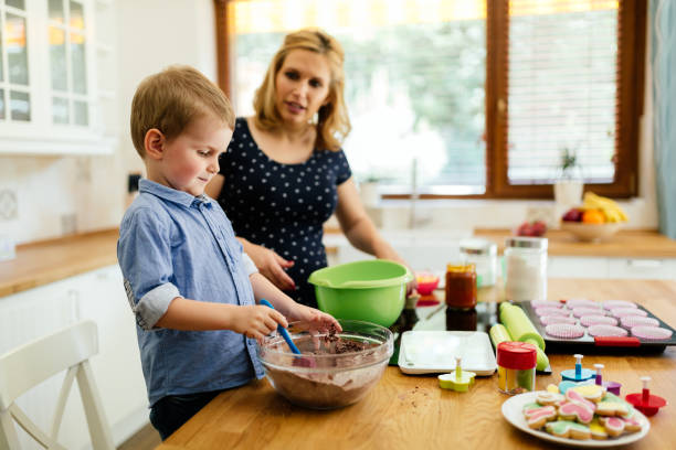 istock Smart cute child helping mother in kitchen 990549706
