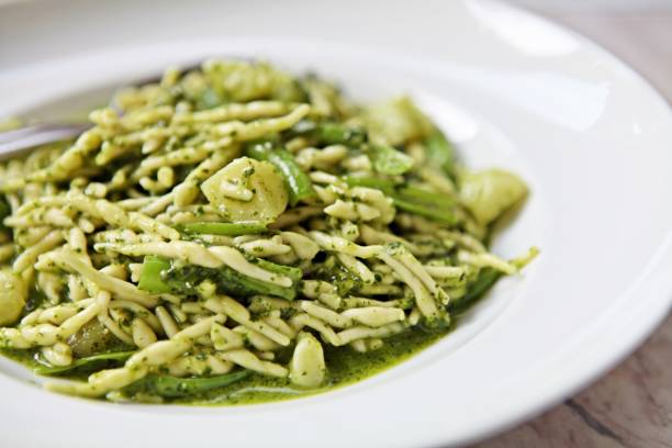 традиционная лигурийская паста trofie ручной работы со свежим соусом pesto alla genovese. - pesto sauce italian culture pine nut photography стоковые фото и изображения