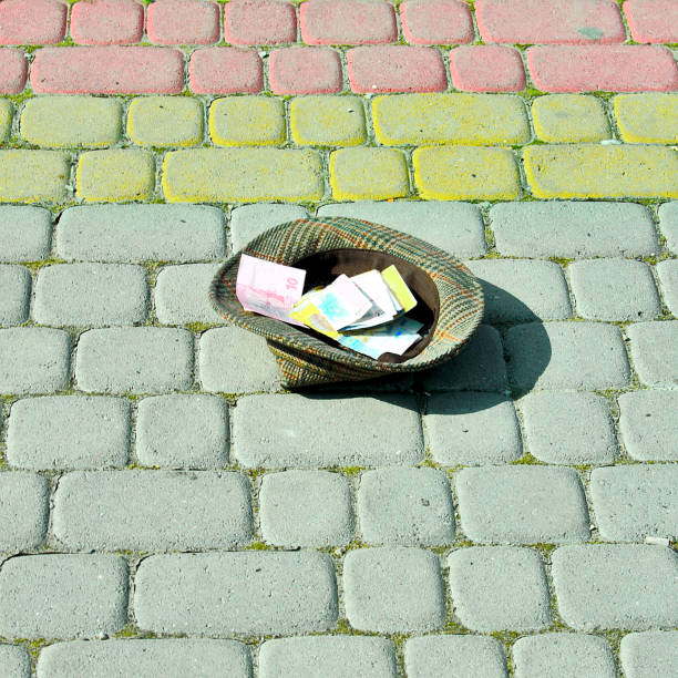 istock hat with money, paving stones, beggars people 990557836