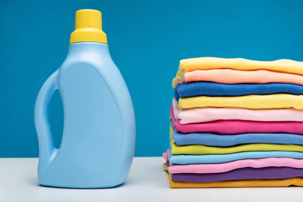 istock Folded t-shirts and washing liquid standing on table 990558454