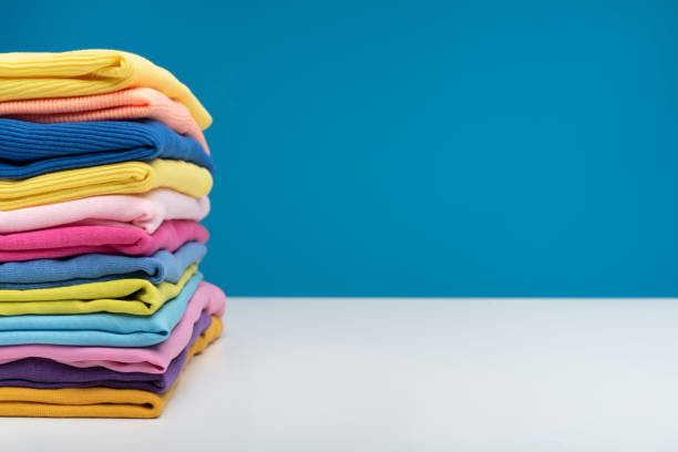 istock Bright garments lying on table after washing 990558572