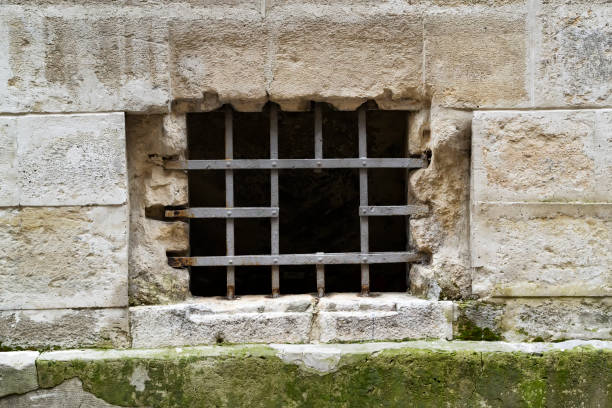 istock A small window with an iron grating on an old stone wall 990562004