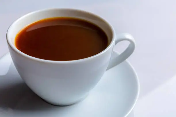 A cup of coffee on a white background, close-up