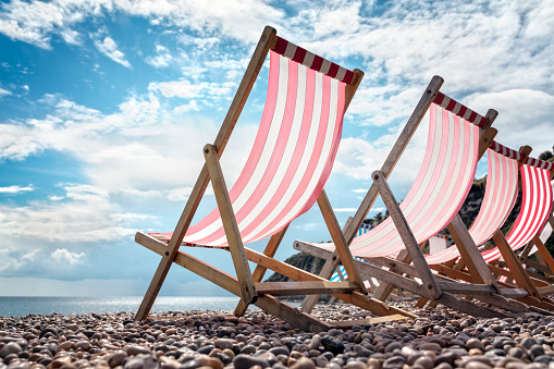 Deck chairs on the beach at the seaside summer vacation