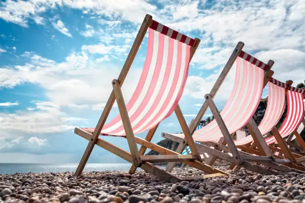 Deck chairs on the beach at the seaside on summer vacation