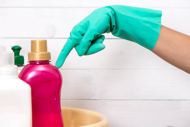 istock Hand In Washing Up Glove With Cleaning Products 990577192