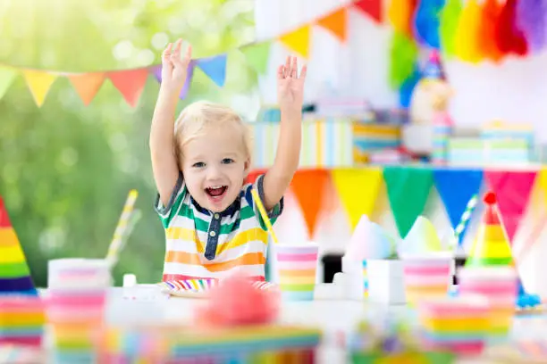 Photo of Kids birthday party. Child blowing out cake candle