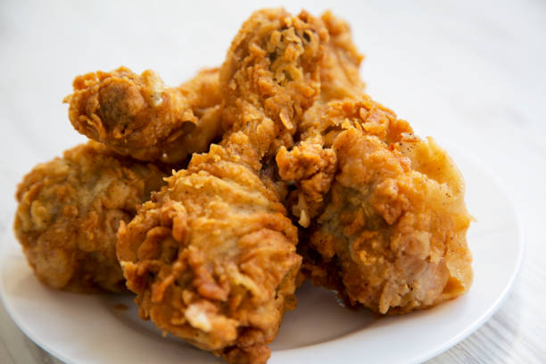 istock Fried chicken legs on a white plate, close-up. 990582122
