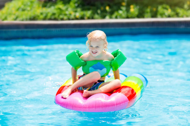 istock Child on inflatable float in swimming pool. 990595670