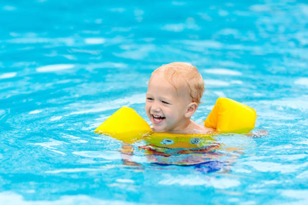 istock Baby in swimming pool. Kids swim. 990598502