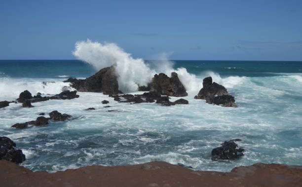 istock Wave splash on rocky coastline in Maui 990598908