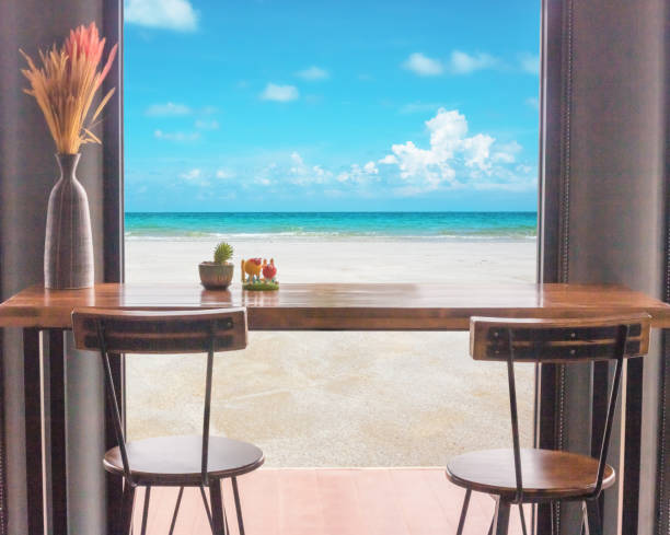 Table and chairs in front of the window with sea view.