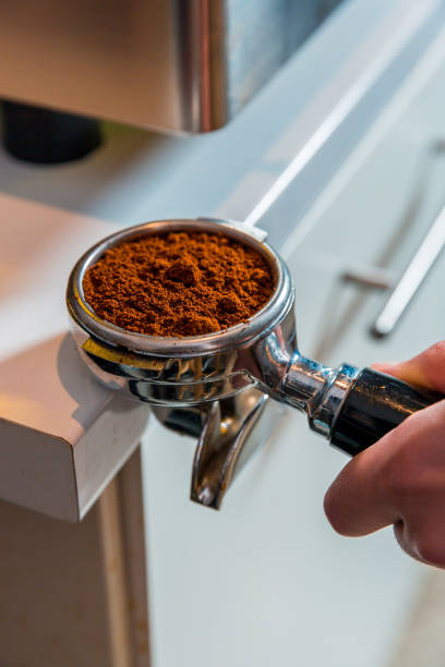 istock Preparing ground coffee with an espresso tamper, in a portafilter 990619932
