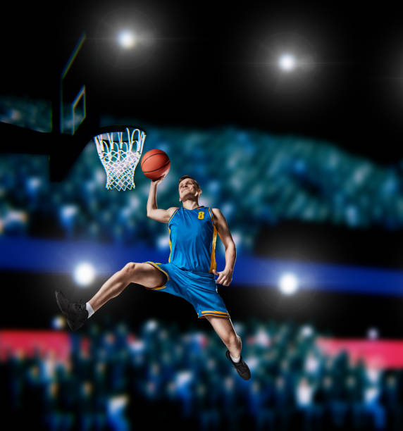 istock basketball player making slam dunk on basketball arena 990639162