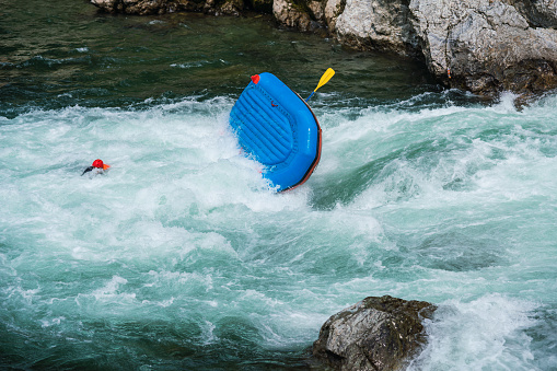 Man floating in a river after his raft flipped over while white water river rafting