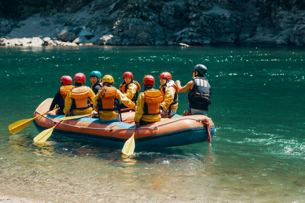 istock Group of men and women in a raft on a river 990646596