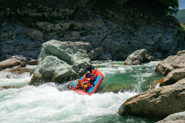 istock Group of men and women white water river rafting 990648976