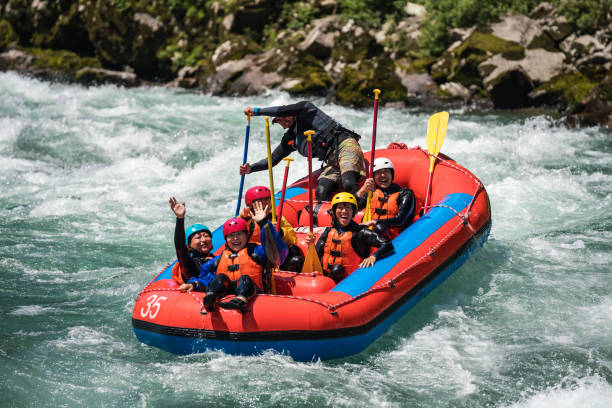 istock Group of men and women white water river rafting 990649222