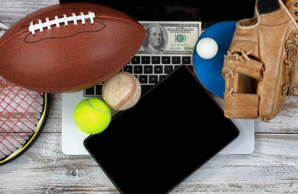 istock Betting on various sports with computer technology and money in background 990649318