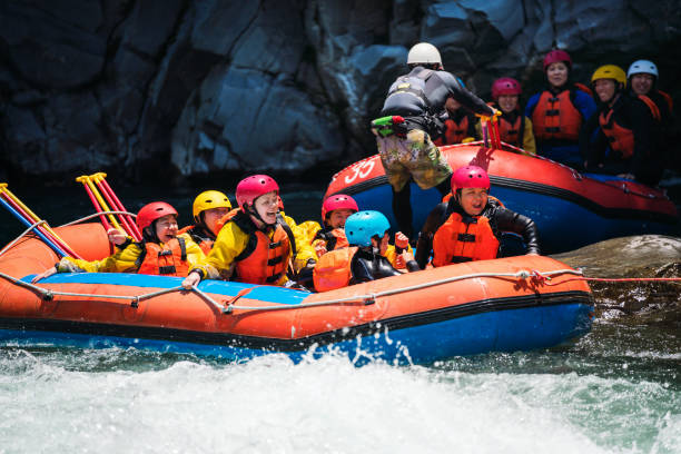 istock Group of men and women white water river rafting 990649664