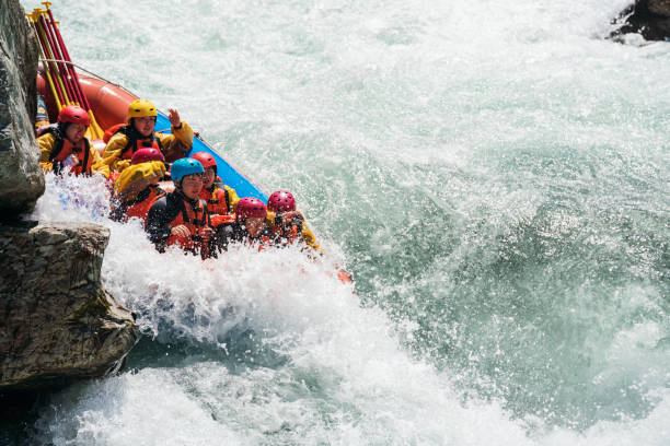 istock Group of men and women white water river rafting 990649836
