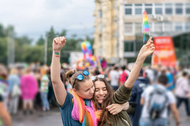 istock Beautiful female couple hugging while marching on the street 990660248