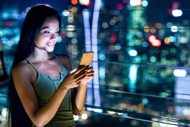 istock Beautiful young woman taking selfie at night 990660616