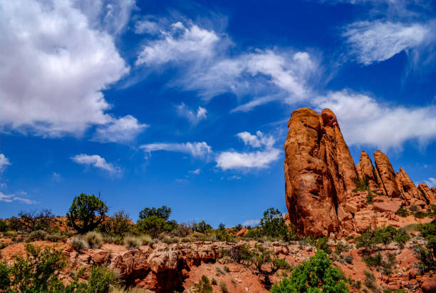 istock Layered and Eroded Sandstone Contrasts with Wispy Clouds in Arches National Park 990664288