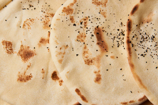 istock Pita bread background on wooden board table 990667312