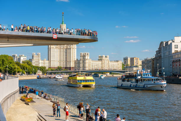 Moscow - June 16, 2018: Tourist ships sail on Moskva River past the Floating bridge in Zaryadye Park, Russia. Zaryadye is one of the main landmarks of Moscow. People relax in Moscow centre in summer.