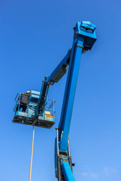 istock Electrical technician repairing street light by boom lift 990681228