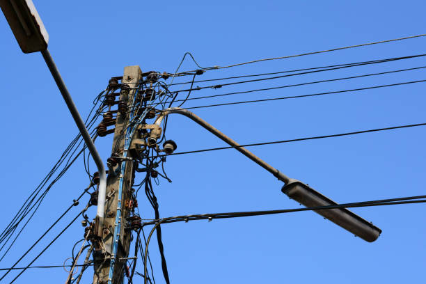 istock electric cement pole with blue sky and messy electric lines 990703780